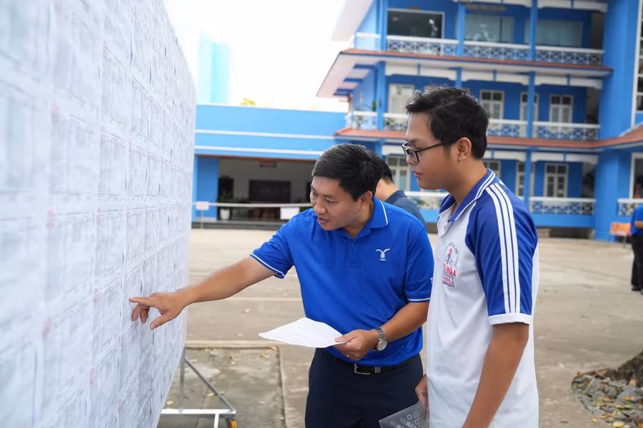 Cán bộ tại điểm thi số 58, Trường Đại học Thủ Dầu Một (TPHCM) hướng dẫn thí sinh tìm phòng thi. Ảnh: TDMU. tdm.jpg