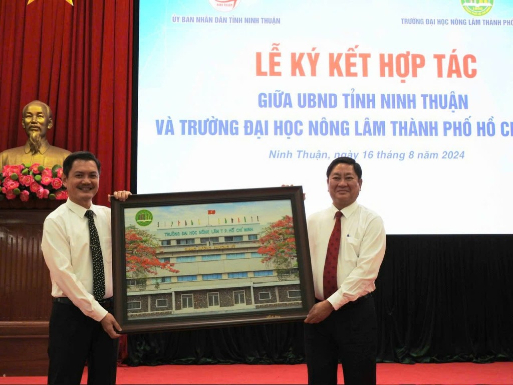 PGS.TS. Nguyễn Tất Toàn, Phó Bí thư Đảng ủy, Hiệu trưởng Trường Đại học Nông Lâm TP Hồ Chí Minh (bên trái) trao quà lưu niệm cho UBND tỉnh Ninh Thuận. ( Ảnh: Lâm Anh)