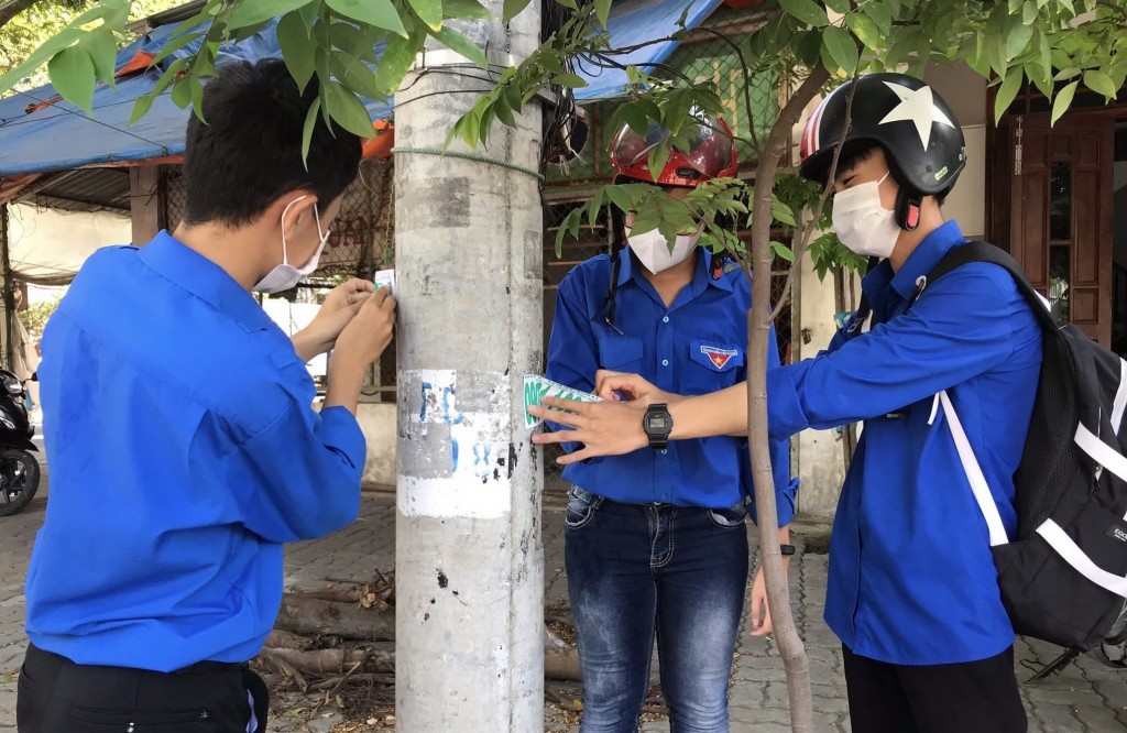 Lực lượng thanh niên xóa các biển quảng cáo rao vặt sai quy định