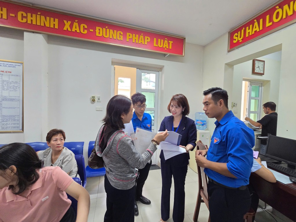 Đồng chí Đào Thị Hoa hướng dẫn người dân thủ tục làm chứng thực cho con nhập học