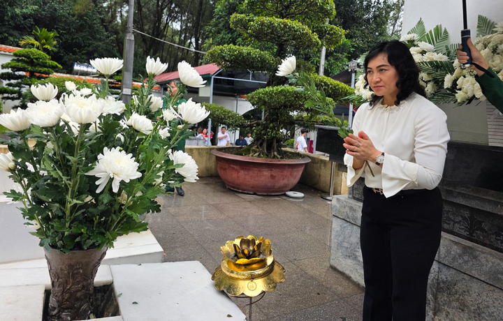 Thứ trưởng Phan Thị Thắng dâng những bông hoa cúc trắng lên phần mộ của các nữ liệt sỹ. Ảnh: Trọng Tùng