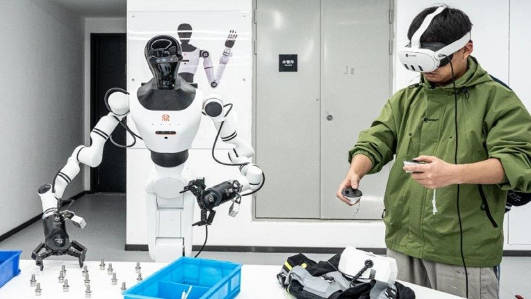 Một người huấn luyện đang hướng dẫn một người máy hình người thực hiện một nhiệm vụ trong quá trình huấn luyện. truong-dao-tao-robot-hinh-nguoi-lan-dau-xuat-hien-2.jpg