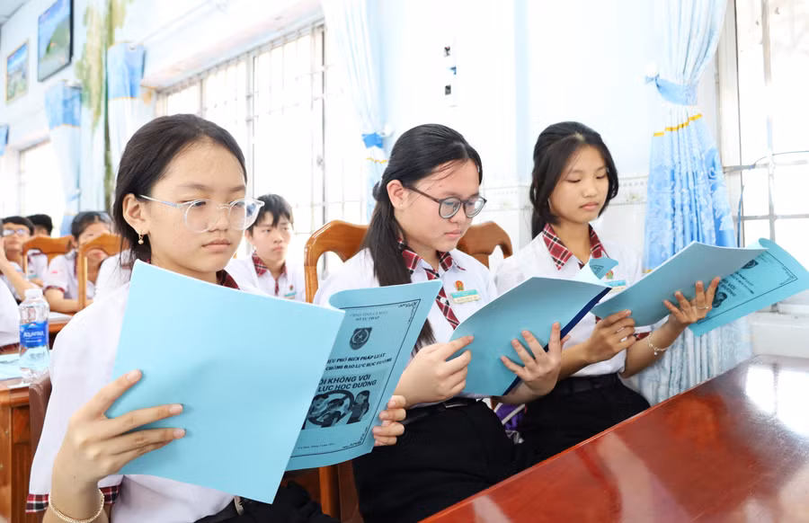 Học sinh đọc tài liệu về phòng chống bạo lực học đường. tuyen-truyen-blhd6.jpg